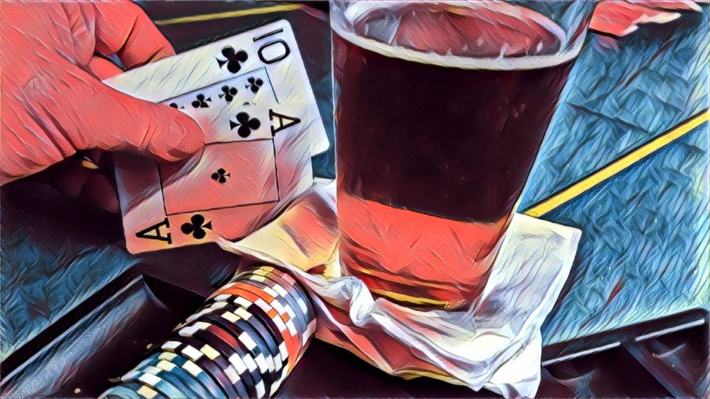 Glass of beer next to a poker hand of Ace of clubs, 10 of clubs